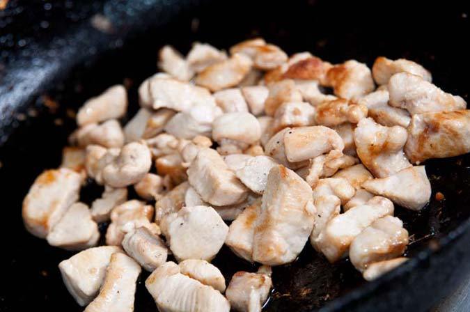 salteando pollo en un wok