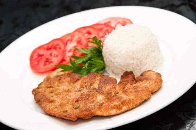 plato de milanesa de pollo con arroz y tomates