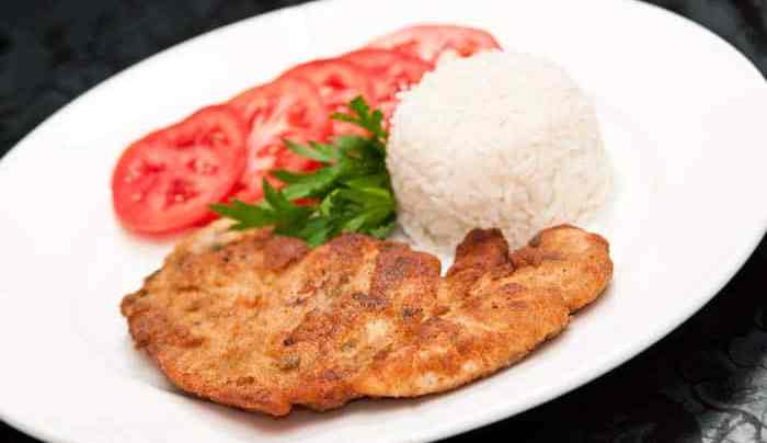 plato de milanesa de pollo con arroz y tomates