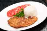 plato de milanesa de pollo con arroz y tomates