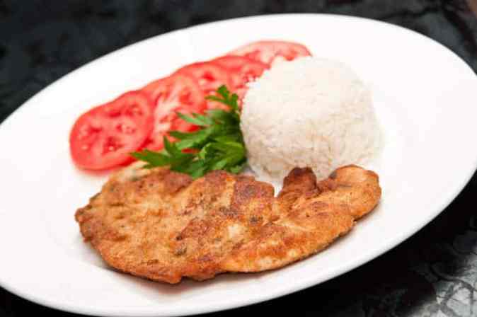 plato de milanesa de pollo con arroz y tomates
