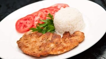 plato de milanesa de pollo con arroz y tomates