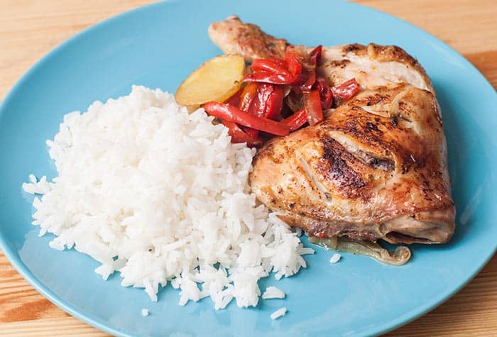 Plato con una pieza de pollo al horno acompañado de patatas y arroz