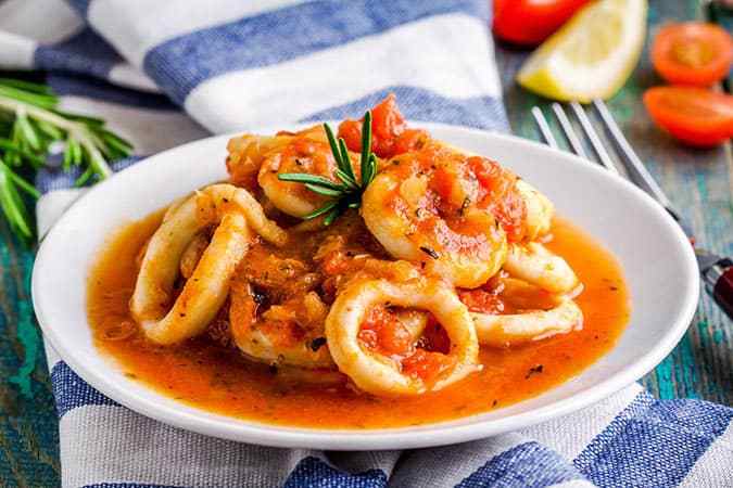 calamares encebollados servidos en un plato bañados en salsa
