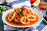 calamares encebollados servidos en un plato bañados en salsa