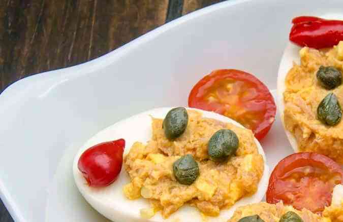 plato con huevos rellenos de atún decoradoc con alcaparras y tomates