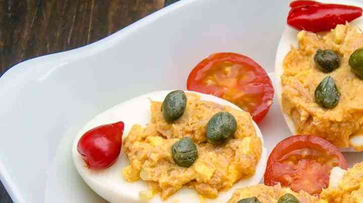 plato con huevos rellenos de atún decoradoc con alcaparras y tomates