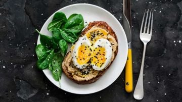 plato con una tosta de hummus con huevo duro