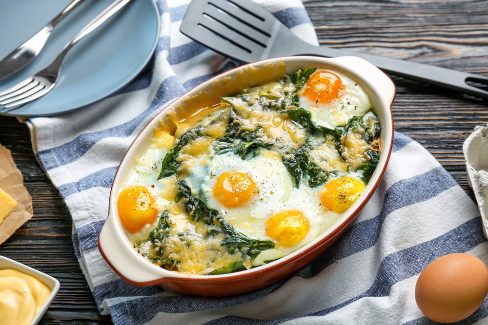 Baking,Dish,With,Delicious,Cooked,Eggs,Florentine,And,Napkin,On