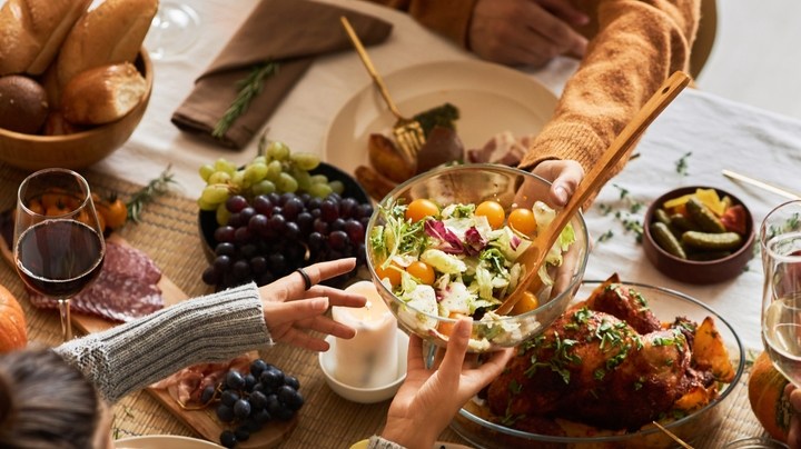 Multiethnic,Group,Of,People,At,Festive,Dinner,Table,Celebrating,Thanksgiving