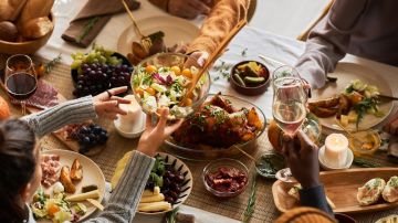 Multiethnic,Group,Of,People,At,Festive,Dinner,Table,Celebrating,Thanksgiving