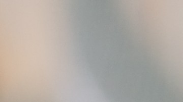 Un plato con osobuco sobre una cama de polenta, hojas de menta y tomates