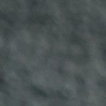 Una sartén con salchichas de lentejas veganas y verduras sobre una mesa gris