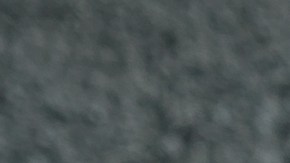 Una sartén con salchichas de lentejas veganas y verduras sobre una mesa gris