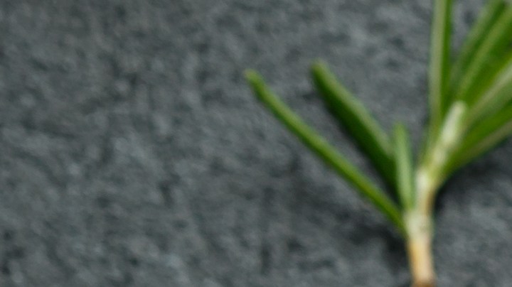 Una sartén con salchichas de lentejas veganas y verduras sobre una mesa gris