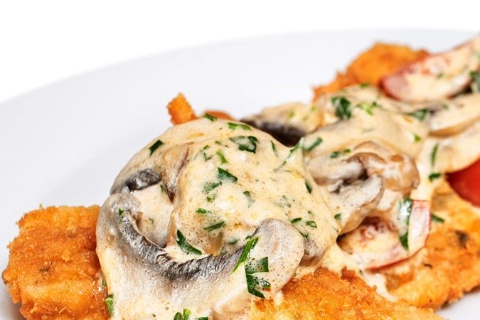 Milanesa de pollo empanizada con salsa de champiñones