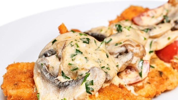 Milanesa de pollo empanizada con salsa de champiñones