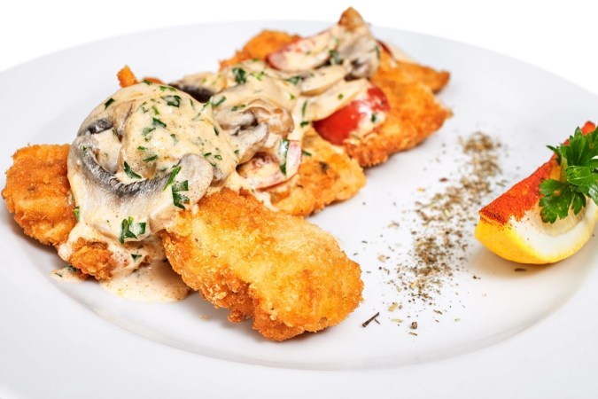 Milanesa de pollo empanizada con salsa de champiñones