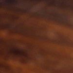 Arepa rellena de pollo desmechado sobre una tabla de madera