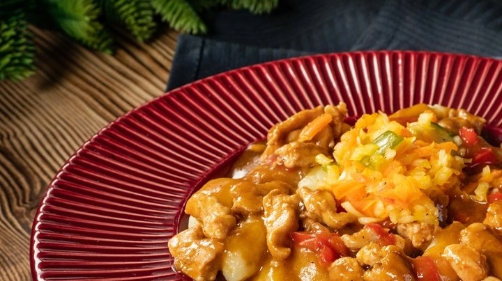 Plato hondo color rojo con fricasé chileno y cubiertos