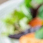 Mesa con mantel marrón con diferentes platos con hamburguesas de carne vegana y papas fritas