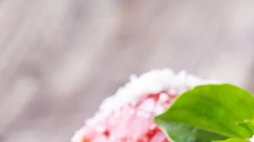 Plato negro con una porción de pappardelle con salsa de tomate y albóndigas sobre una pared de madera