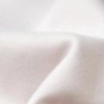 Plato blanco con pasta rigatoni con salsa de nueces sobre un mantel blanco