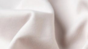 Plato blanco con pasta rigatoni con salsa de nueces sobre un mantel blanco