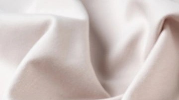 Plato blanco con pasta rigatoni con salsa de nueces sobre un mantel blanco