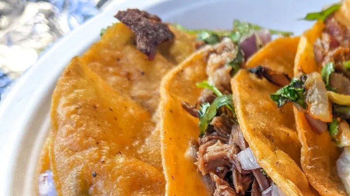 Un plato con tacos de quesabirria y salsas