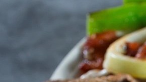 Plato blanco con alambre mexicano y aguacate sobre una mesa gris