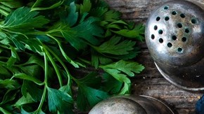Berenjenas rellenas de carne, queso y verduras sobre un plato de aluminio, decorada con verduras