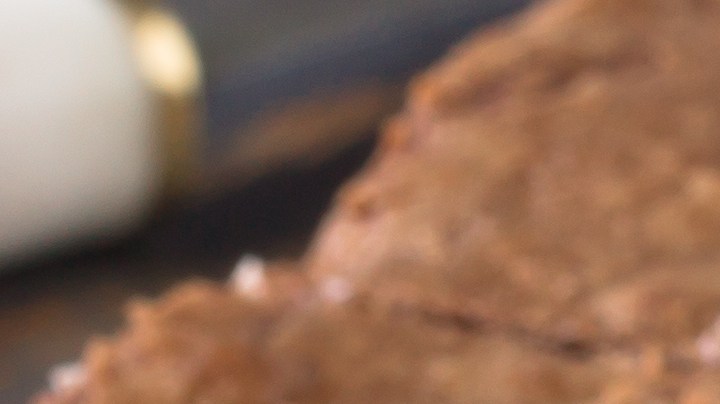 Cheesecake brownie cortados en cuadros sobre una mesa con papel encerado