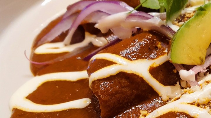 Plato con enmoladas de huevo con mole y aguacate