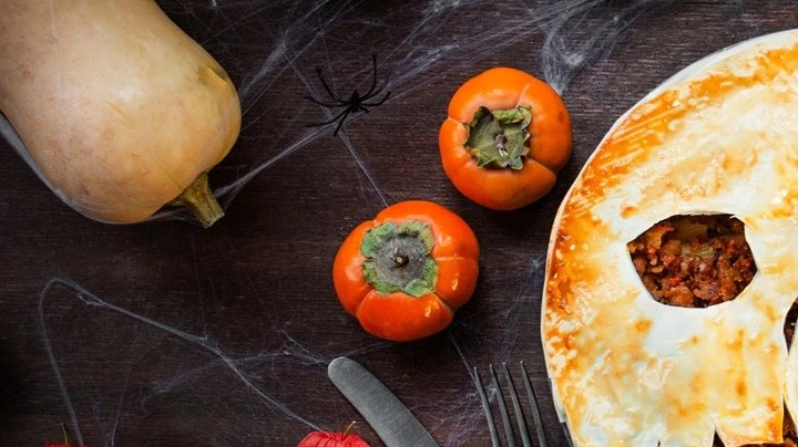 Mesa decorada con alusión a Halloween, incluido un pie de carne en forma de calabaza