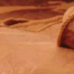 Tabla de madera con un frasco de vidrio con paté de pimientos de piquillo, untado en pedazos de pan