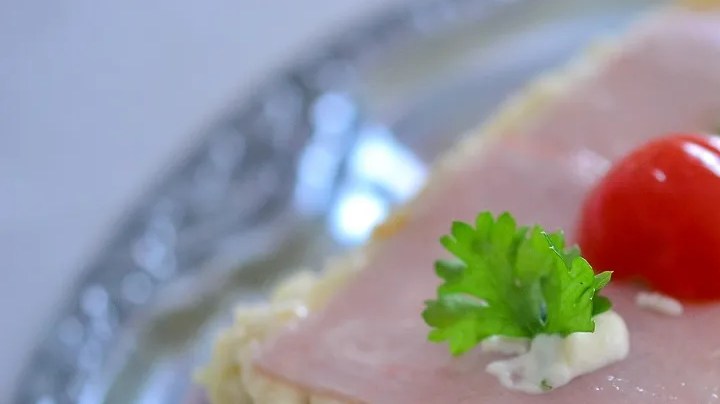 Bandeja de mental con un sanduchón venezolano decorado con jamón y fresas