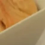 Plato blanco con sándwich de serpentinas con diablito y tres recipientes de salsas