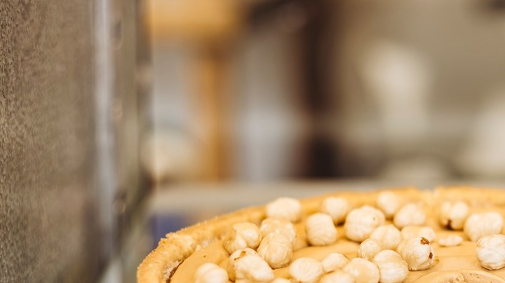 Bandeja de plata con una tarta de queso con avellanas