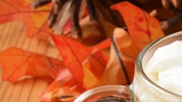Tazas de café navideño decorado con crema batida sobre una mesa de madera