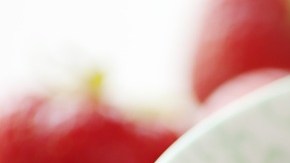 Porción de compota de frutos rojos en un recipiente blanco decorado con frutillas