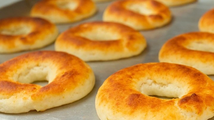 Bandeja metálica con varios pandequeso horneados en forma toroidal con un agujero en el centro