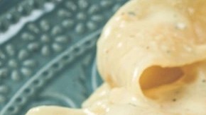 Pasta Pappardelle con salsa cremosa y parmesano sobre un plato verde y un tenedor