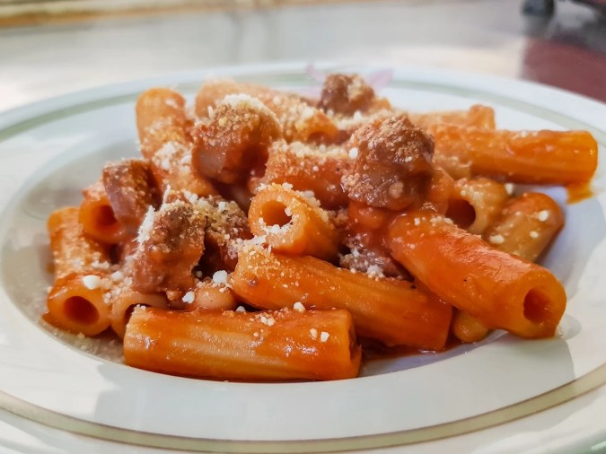Plato blanco hondo con pasta rigatoni con chorizo y queso