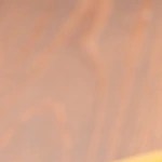 Rigatoni con espárragos en un plato negro sobre una mesa de madera