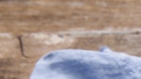 Olla negra con rigatoni con pesto sobre una mesa de madera decorado con cubiertos