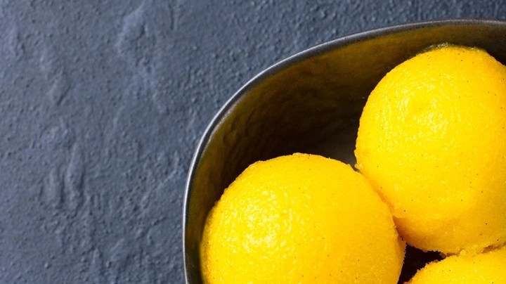 Plato hondo color negro con tres bolas de sorbete de maracuya y menta