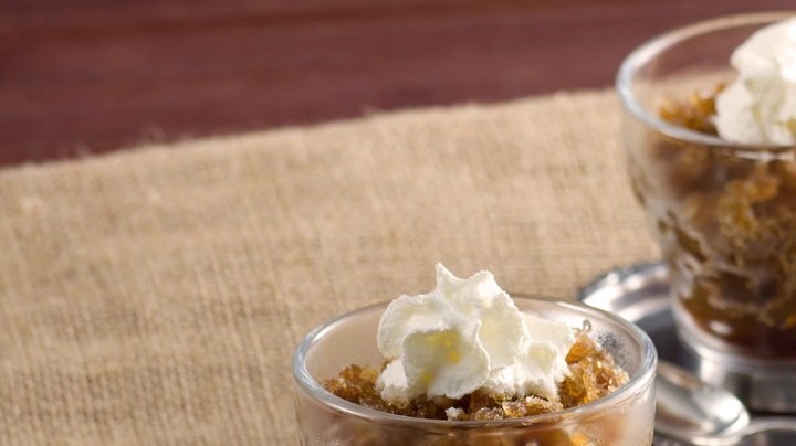 Sorbete de café frío decorado con crema y servido en dos tazas de vidrio sobre un plato