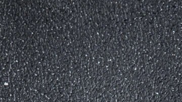 Paté de cangrejo servido sobre pan artesanal crujiente acompañado de hojas verdes frescas en un plato blanco.