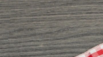 Buñuelos de nata sobre un plato negro y un mantel de cuadros rojo y blanco